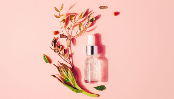 Serum in a bottle against a pink background