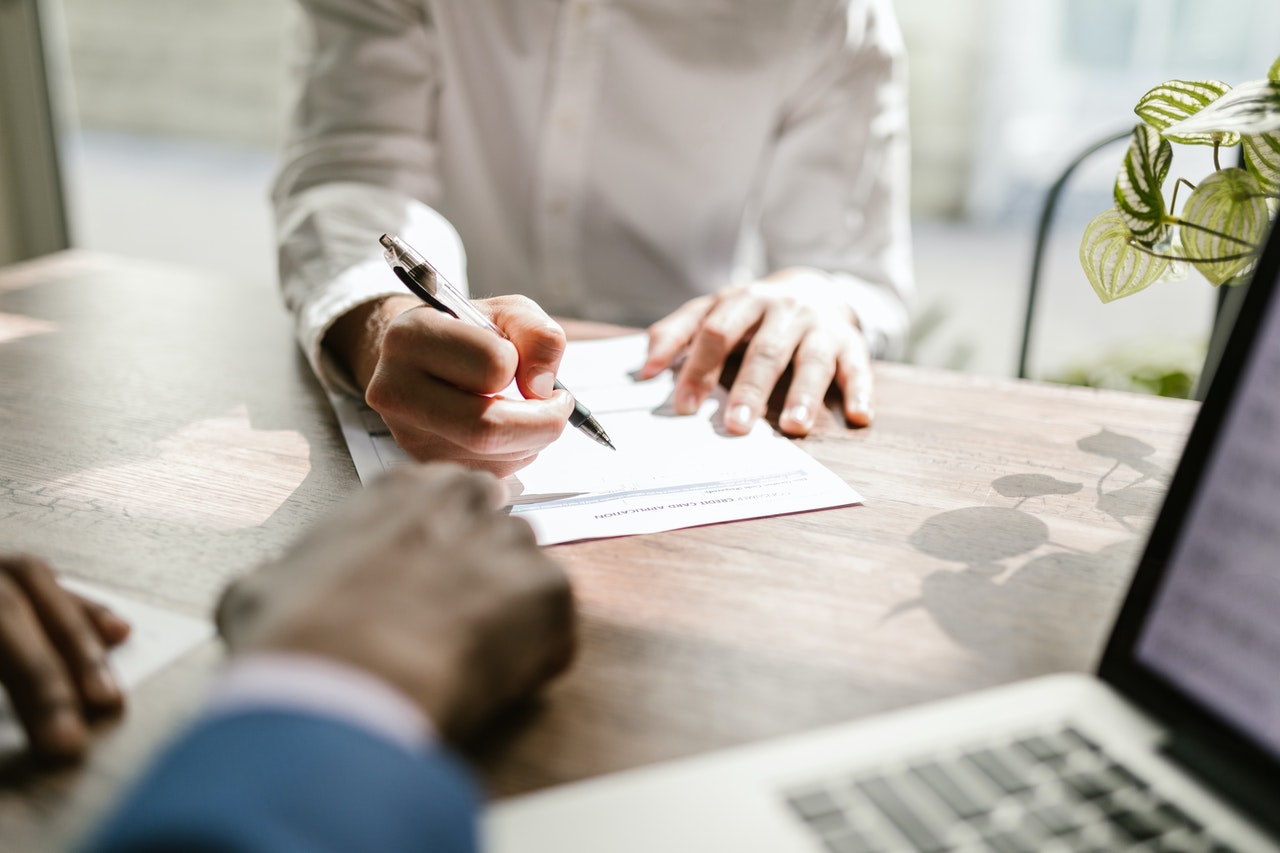 Close up image of a hand filling a loan form