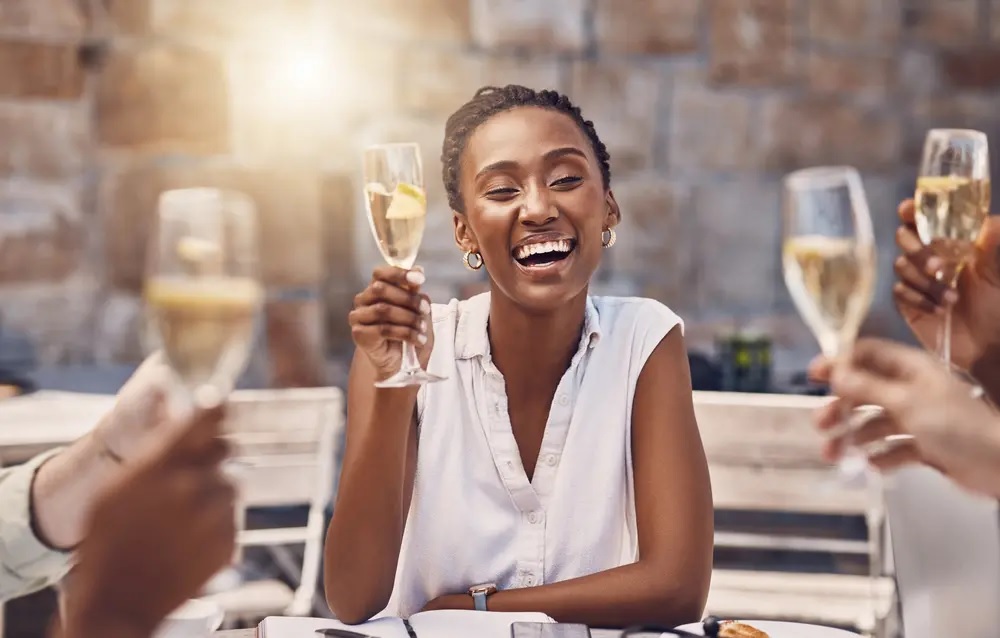 Black woman enjoying champagne with a group of other people